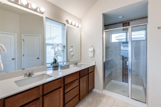 bathroom featuring double vanity, a shower stall, lofted ceiling, and a sink