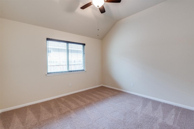 carpeted empty room featuring lofted ceiling, a ceiling fan, and baseboards