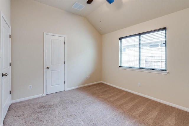 carpeted spare room with visible vents, lofted ceiling, baseboards, and ceiling fan