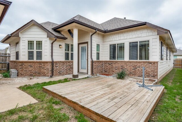 108 Trailstone Dr, Bastrop, TX 78602 - view of front of house with brick siding, a wooden deck, and a shingled roof