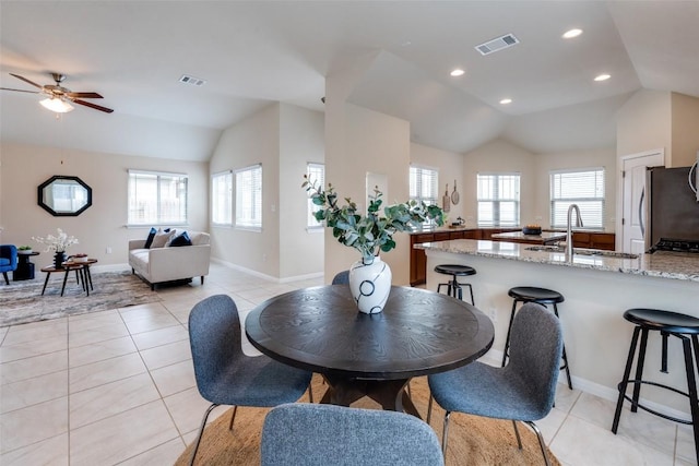 dining space with lofted ceiling, light tile patterned flooring, visible vents, and ceiling fan