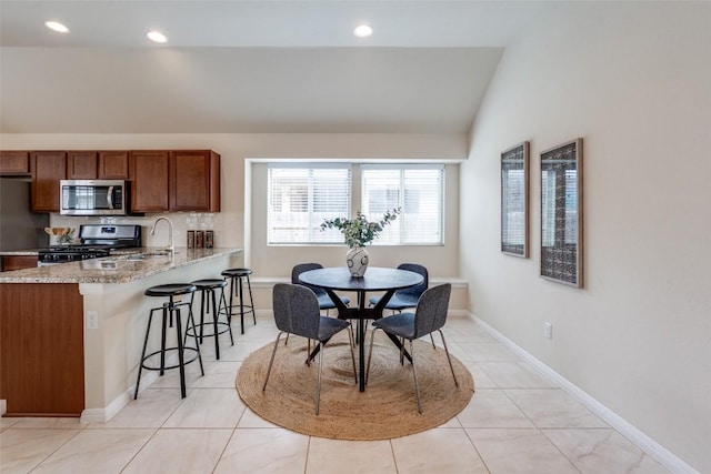 dining area with recessed lighting, baseboards, lofted ceiling, and light tile patterned flooring