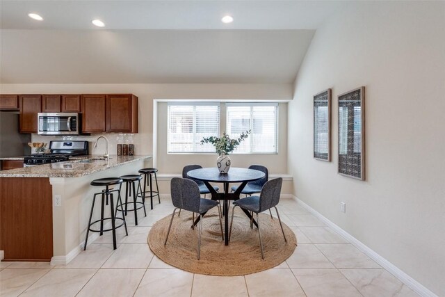 108 Trailstone Dr, Bastrop, TX 78602 - dining area featuring vaulted ceiling, light tile patterned floors, recessed lighting, and baseboards