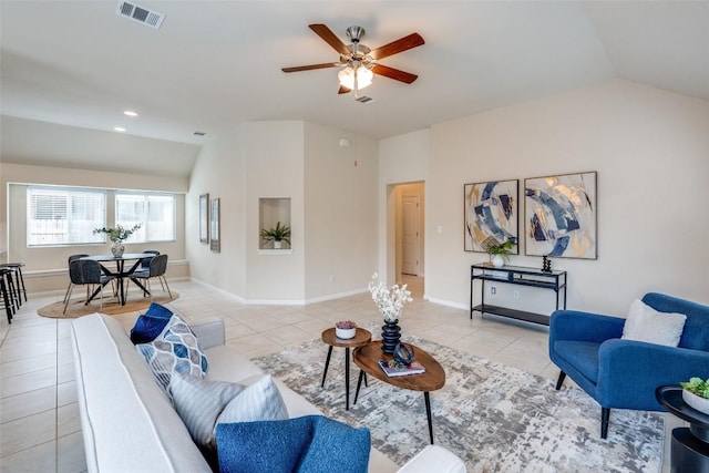 living area featuring visible vents, lofted ceiling, light tile patterned flooring, and a ceiling fan