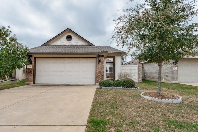 view of front of home with an attached garage, a shingled roof, concrete driveway, a front lawn, and brick siding