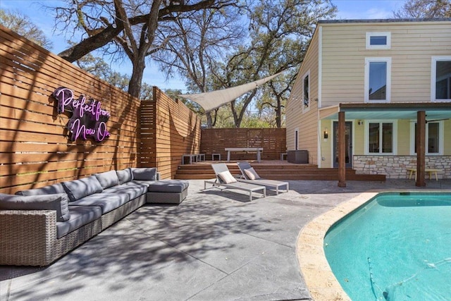 view of swimming pool with a fenced in pool, an outdoor hangout area, a wooden deck, and a patio