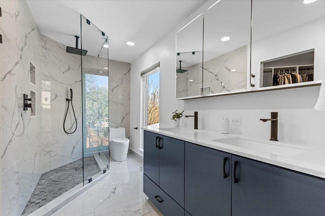 bathroom with a marble finish shower, marble finish floor, toilet, and a sink