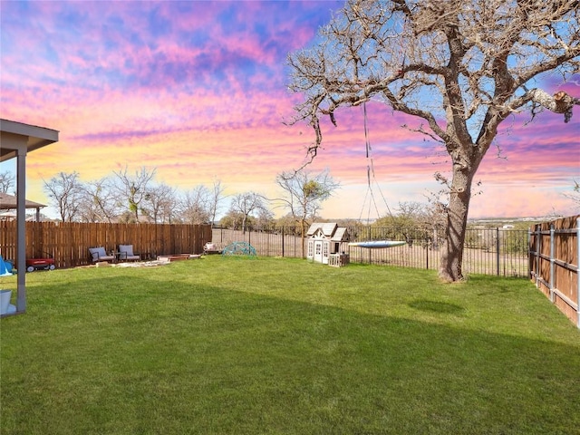 yard at dusk with a fenced backyard