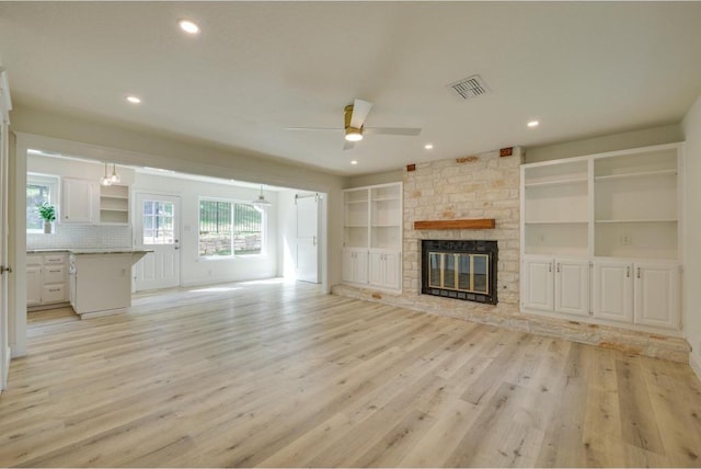 unfurnished living room with visible vents, recessed lighting, light wood-style floors, a fireplace, and ceiling fan