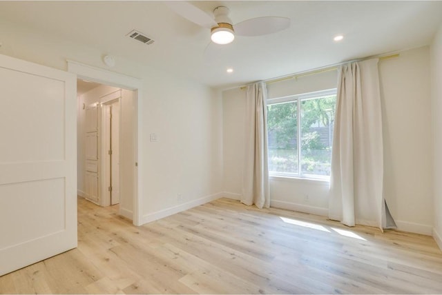 spare room featuring ceiling fan, baseboards, visible vents, and light wood-type flooring