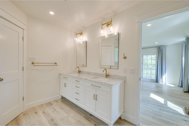 full bathroom with double vanity, recessed lighting, wood finished floors, and a sink