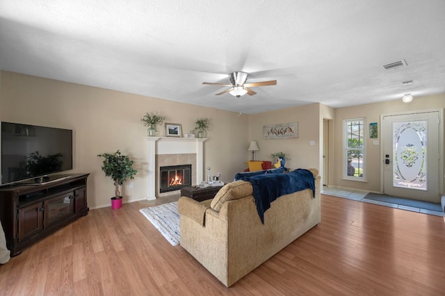1807 Morning Quail Dr, Austin, TX 78758 - living area featuring a tiled fireplace, light wood-style floors, ceiling fan, and baseboards