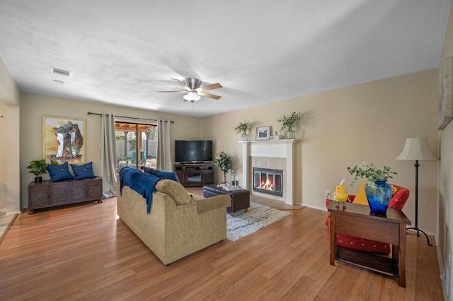 1807 Morning Quail Dr, Austin, TX 78758 - living area featuring light wood-style flooring, a tile fireplace, ceiling fan, and baseboards