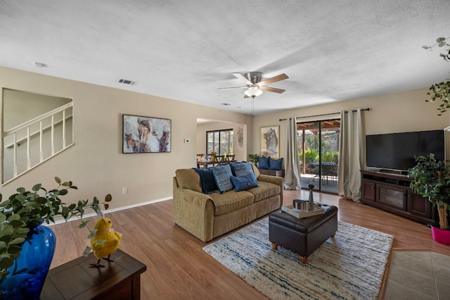 1807 Morning Quail Dr, Austin, TX 78758 - living room with a ceiling fan, stairway, wood finished floors, a textured ceiling, and baseboards