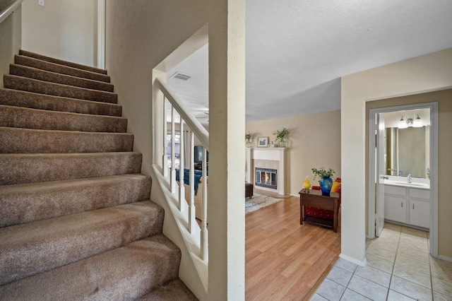 1807 Morning Quail Dr, Austin, TX 78758 - staircase with a fireplace and wood finished floors