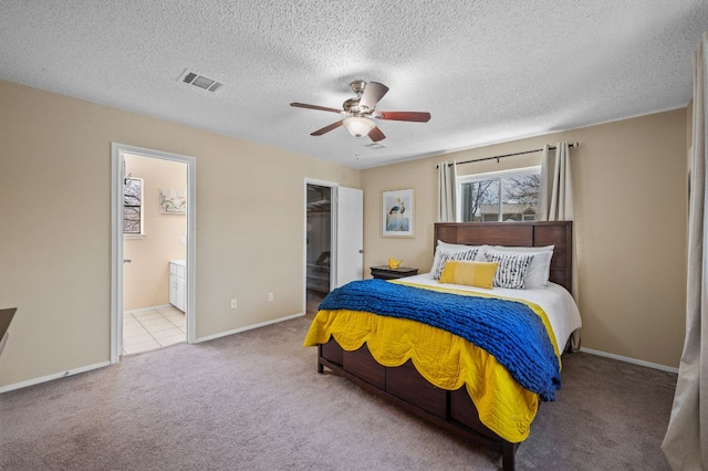 1807 Morning Quail Dr, Austin, TX 78758 - carpeted bedroom featuring connected bathroom, a textured ceiling, a closet, baseboards, and a walk in closet