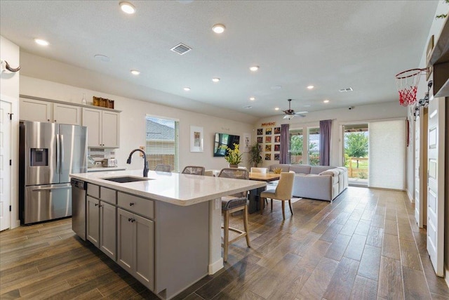 kitchen with visible vents, dark wood-type flooring, light countertops, stainless steel appliances, and a sink