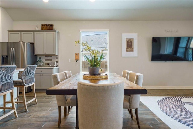 dining area with baseboards and dark wood-style flooring