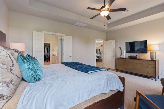 bedroom with visible vents, carpet flooring, and a raised ceiling