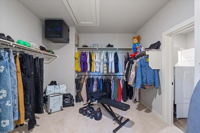 spacious closet with washer / clothes dryer, attic access, and carpet