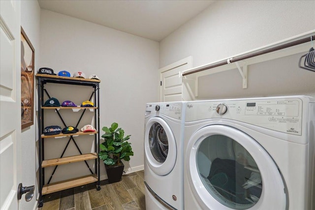 washroom with dark wood finished floors, laundry area, washing machine and dryer, and baseboards