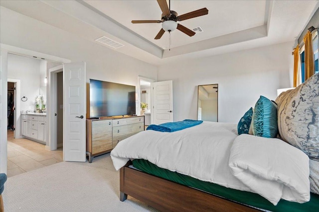 bedroom featuring light tile patterned flooring, visible vents, light colored carpet, and a raised ceiling