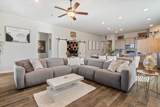 living area featuring visible vents, dark wood-style floors, recessed lighting, a barn door, and ceiling fan