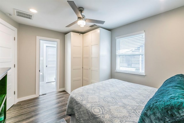 bedroom featuring a ceiling fan, baseboards, visible vents, dark wood finished floors, and a closet