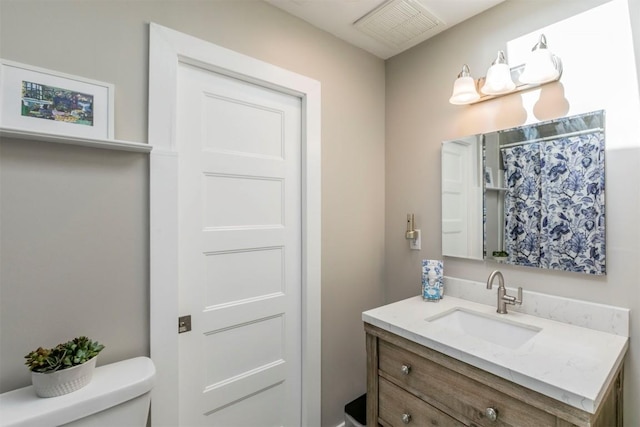 full bath featuring vanity, toilet, and visible vents