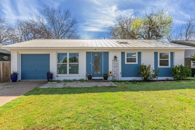 ranch-style home featuring metal roof, a front yard, an attached garage, and concrete driveway