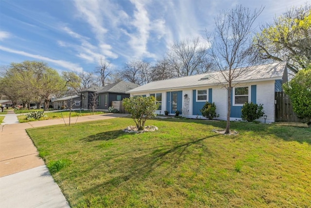 ranch-style house featuring a front lawn, fence, and driveway