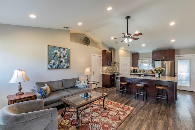 living room featuring lofted ceiling, recessed lighting, a ceiling fan, and dark wood finished floors