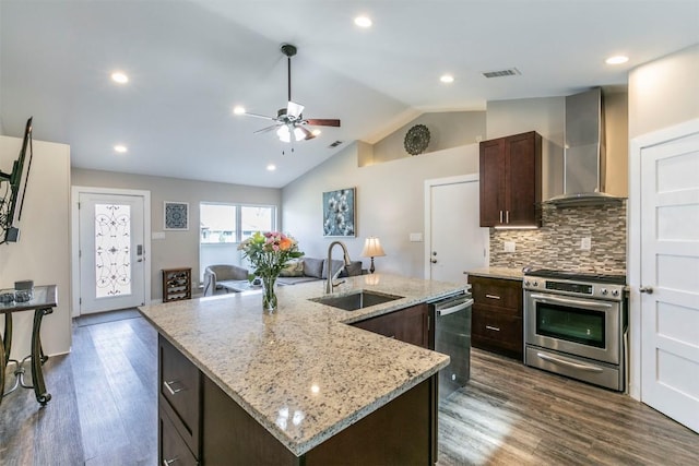 6519 Pevensey Dr, Austin, TX 78745 - kitchen with appliances with stainless steel finishes, wall chimney exhaust hood, a ceiling fan, dark brown cabinetry, and dark wood finished floors