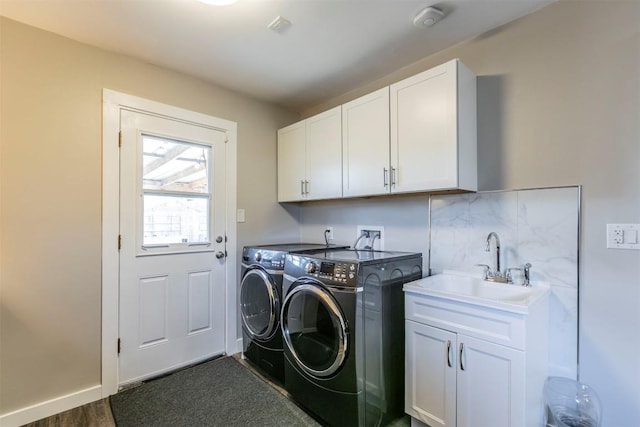 laundry room featuring washer and dryer, cabinet space, baseboards, and a sink