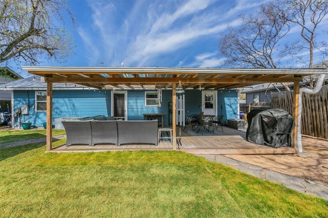 back of house featuring a yard, a deck, outdoor lounge area, and fence