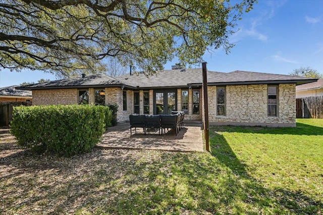 back of house featuring a patio, fence, a lawn, and stone siding