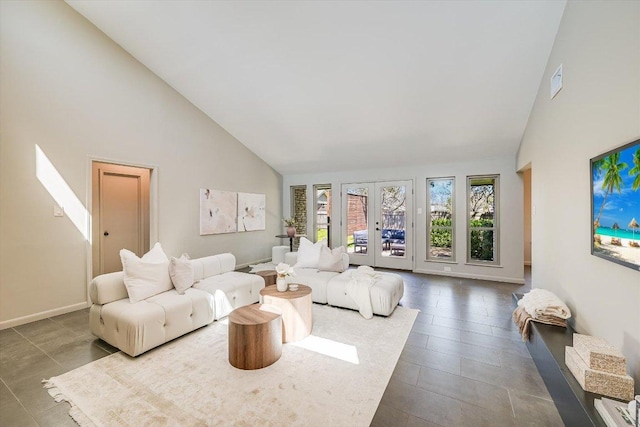 living room featuring high vaulted ceiling and baseboards