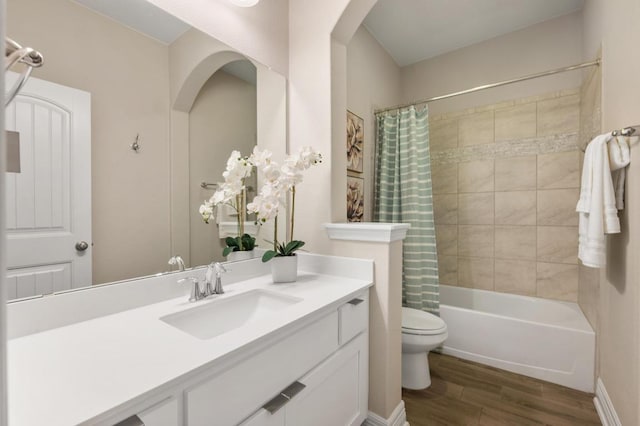 bathroom featuring shower / bathtub combination with curtain, toilet, wood finished floors, and vanity