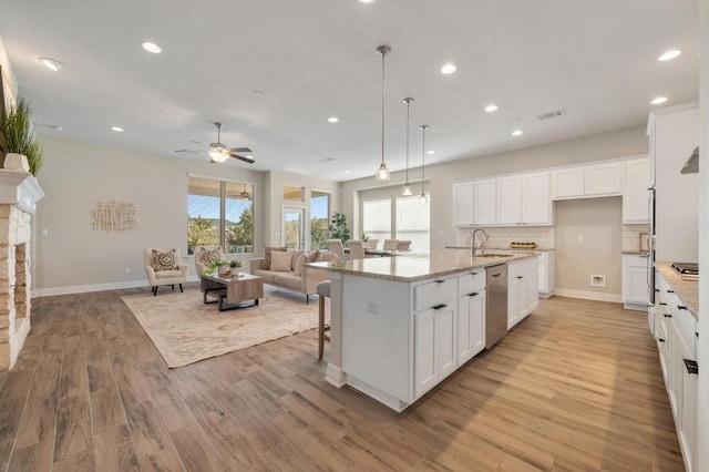 kitchen with visible vents, a sink, open floor plan, stainless steel appliances, and ceiling fan