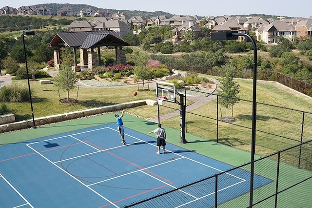 view of sport court with a lawn, community basketball court, fence, a gazebo, and a residential view