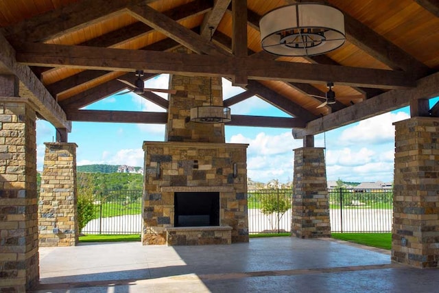 view of patio with a gazebo, an outdoor stone fireplace, a ceiling fan, and fence