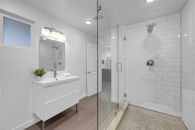 bathroom with visible vents, a stall shower, vanity, and baseboards