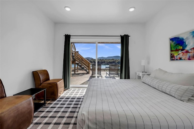 bedroom with recessed lighting, a mountain view, and access to exterior