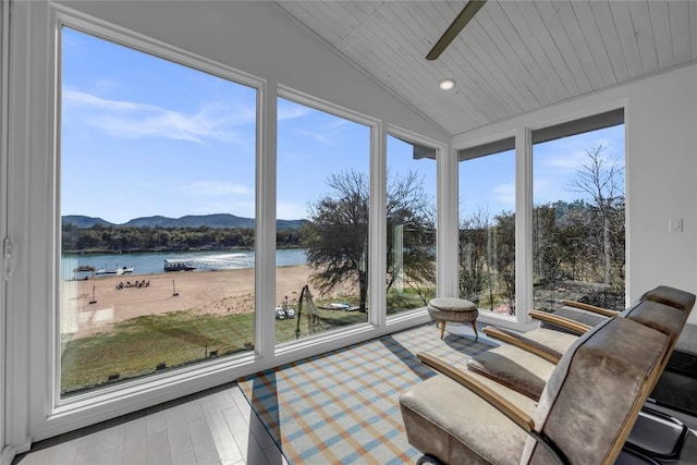 sunroom / solarium featuring vaulted ceiling, wood ceiling, a ceiling fan, and a water view