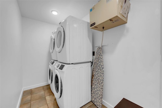 laundry area featuring laundry area, baseboards, and stacked washer and clothes dryer