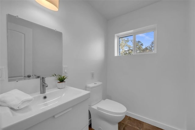 bathroom with a sink, baseboards, and toilet