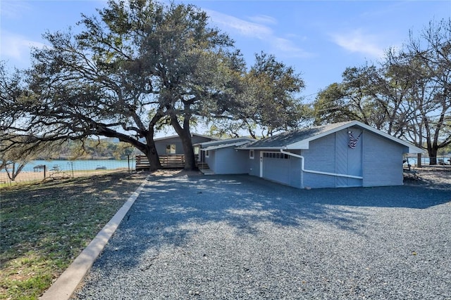 view of side of property with driveway and a water view