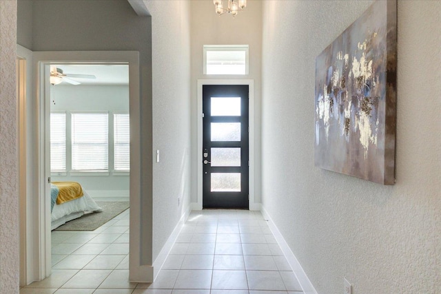 foyer entrance featuring baseboards, plenty of natural light, and light tile patterned flooring