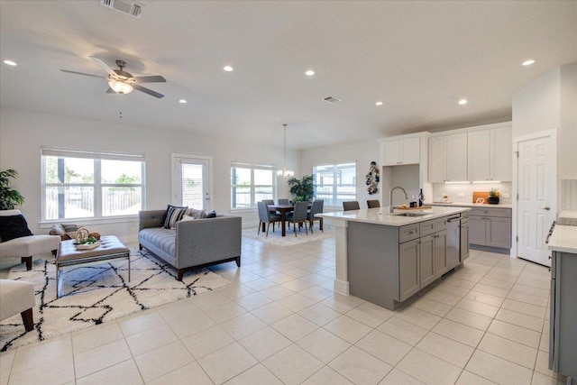 kitchen featuring gray cabinetry, a sink, open floor plan, light countertops, and light tile patterned floors