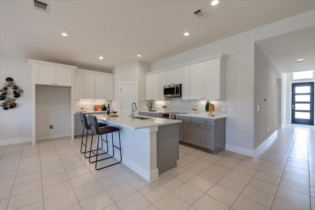 kitchen featuring a sink, stainless steel appliances, visible vents, and light tile patterned flooring